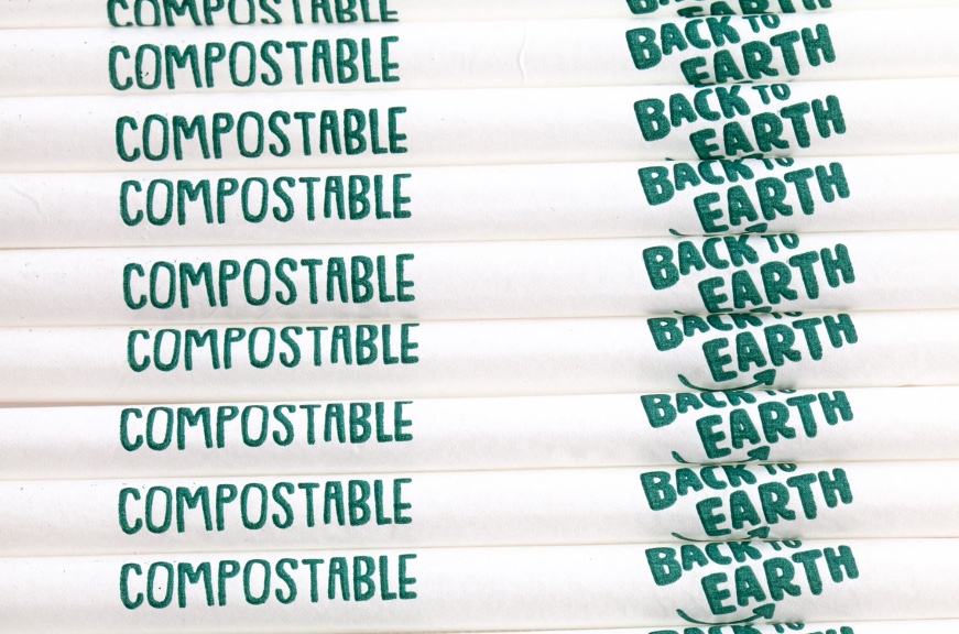line of straws with white paper covers that say "Back to Earth" as well as "compostable" on them