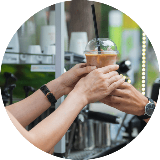 barista handing iced coffee to customer