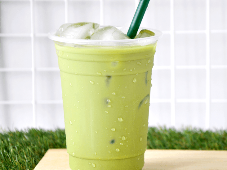 closeup of green drink in clear drinking cup with green straw