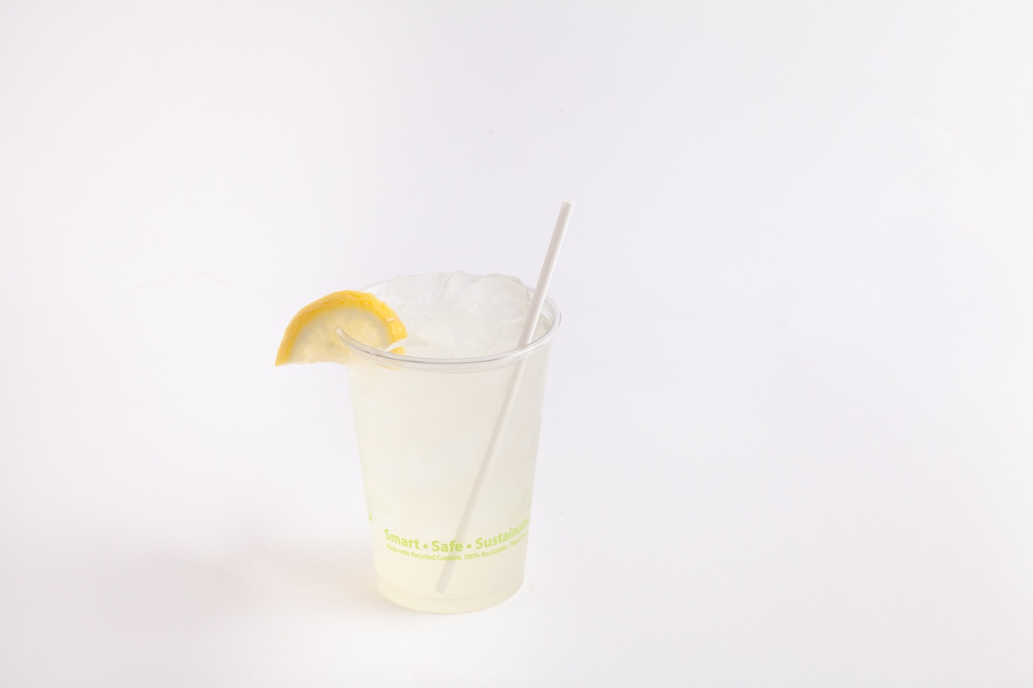 clear drinking cup with lemonade and straw
